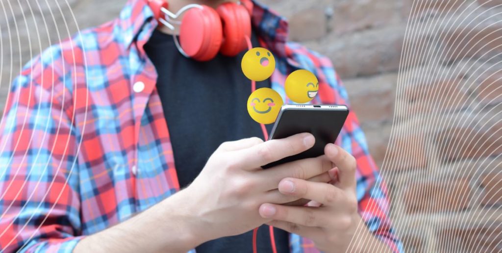 Man typing on phone with emojis