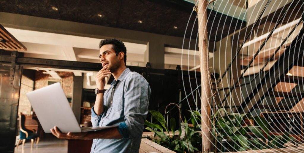 Man holding laptop in office