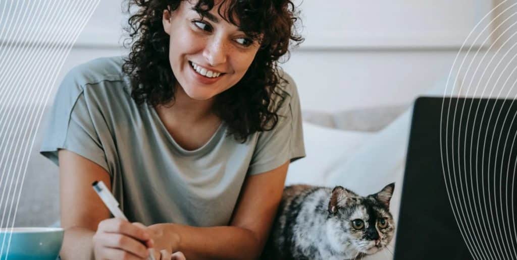 Woman writing notes next to her cat